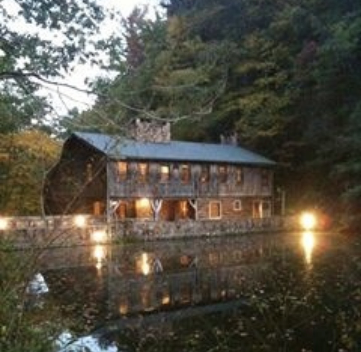 Long Creek Lodge at dusk, its lit windows reflected in the still lake