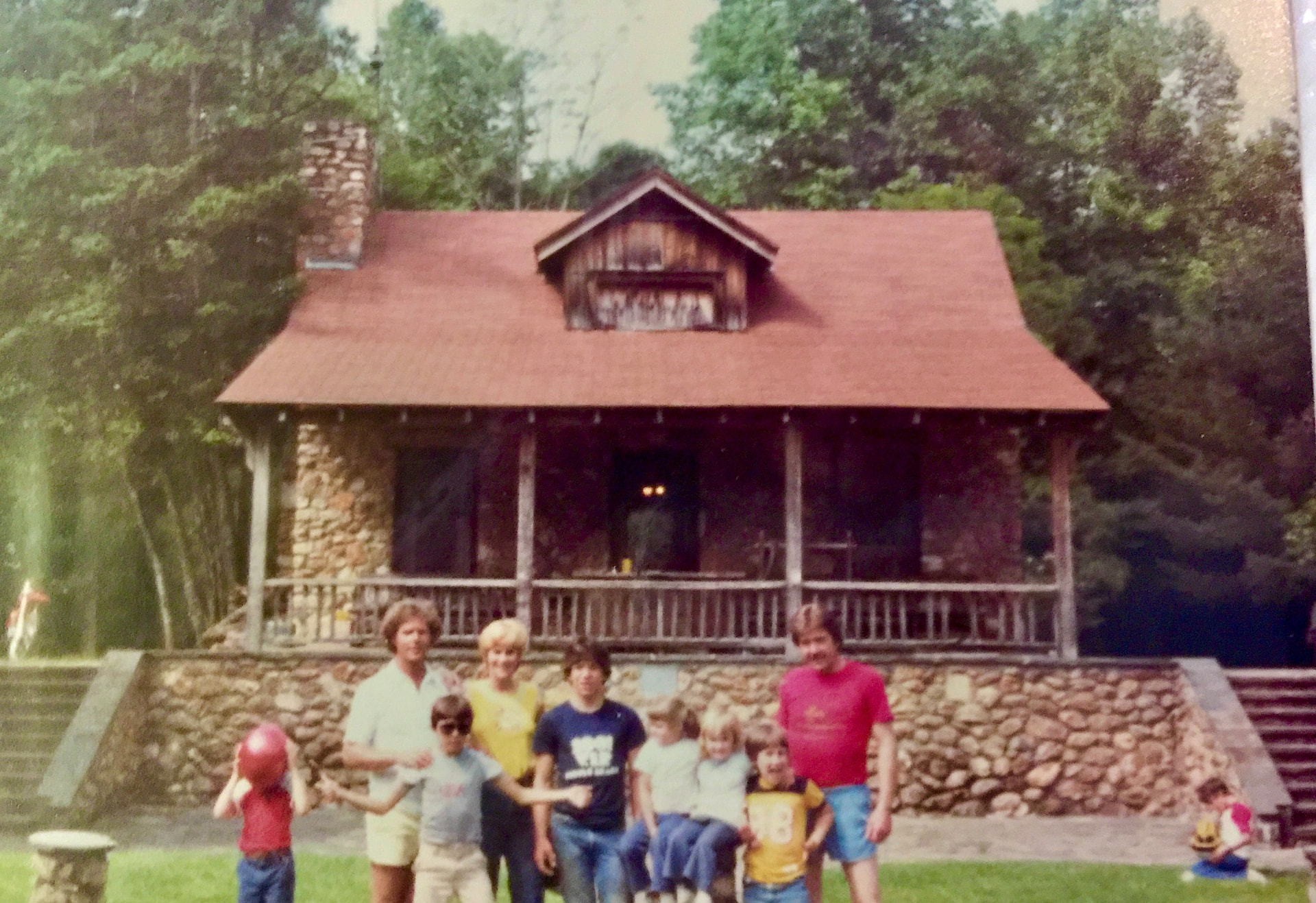 Zach and Will Reynolds with Blitz Reynolds and friends gathered on the lawn in front of the stone Skeet House with its red shingled roof