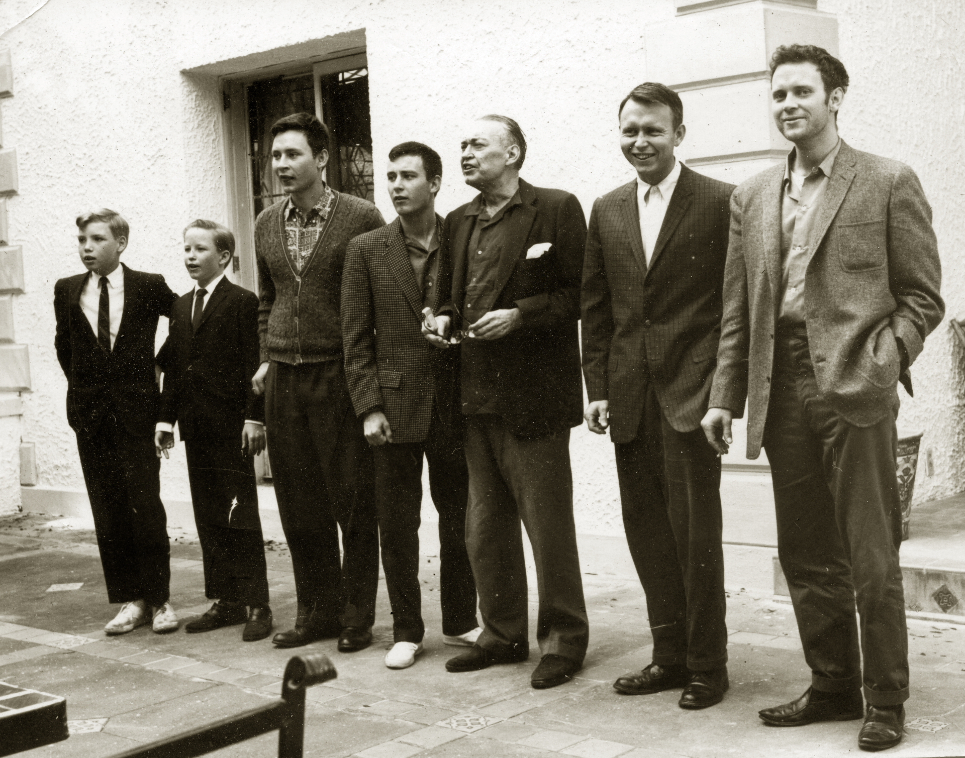 Dick Reynolds standing outdoors with his sons and the younger boys of the family, all in coats and ties