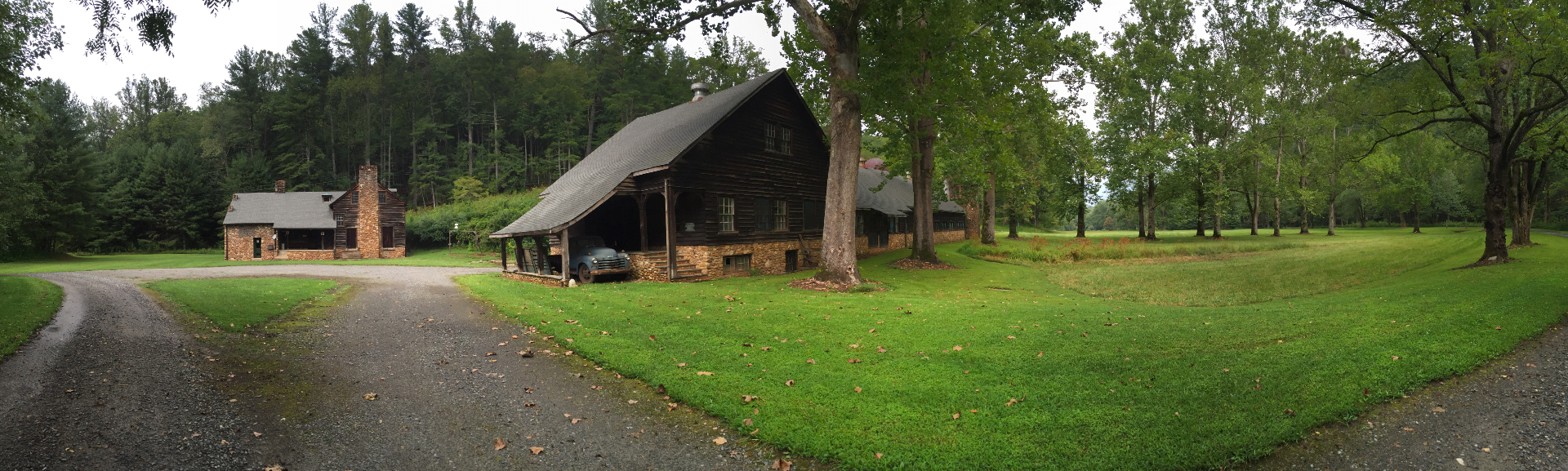 The stone and chestnut farm compound at Devotion with green fields beyond